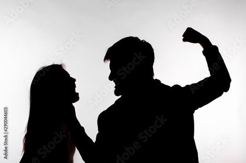 Aggression and abuse concept - man and woman expressing domestic violence in studio silhouette isolated on white background.