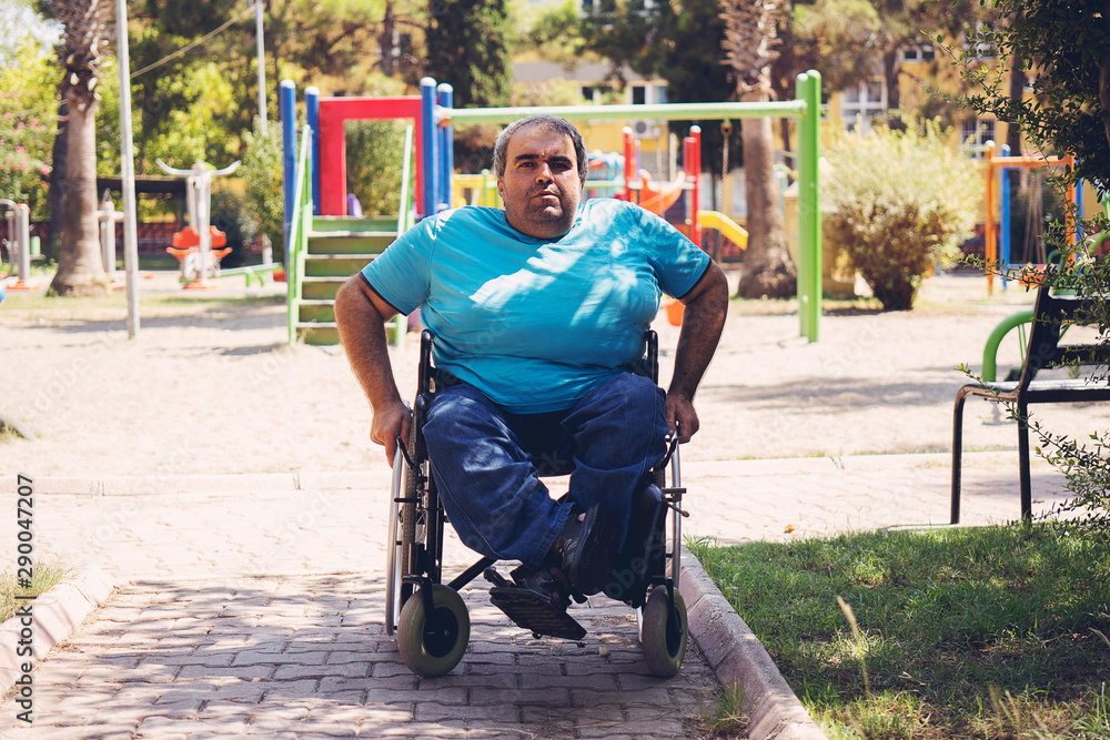 Obraz premium disabled man in wheelchair walking park