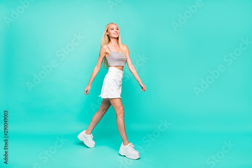 Full length body size view of nice-looking attractive winsome sportive cheery content slender straight-haired model walking podium isolated over bright vivid shine green blue turquoise background