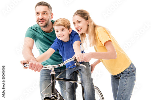 smiling parents teaching son to ride bike isolated on white