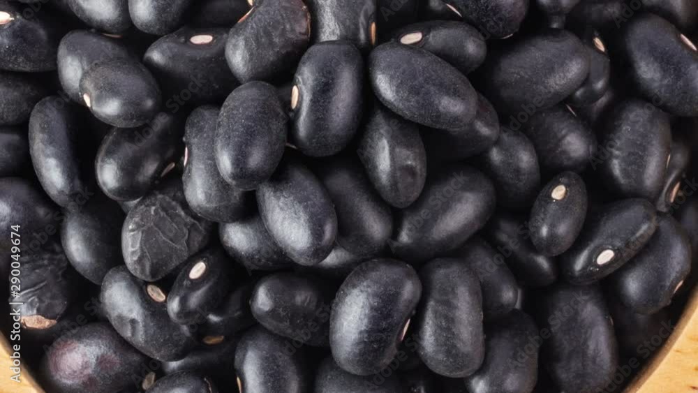 panning black beans in wood bowl isolated on white background. top view panning black beans in wood bowl isolated on white background. top view
