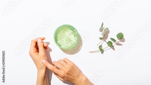 Female s hands applying aloe vera gel