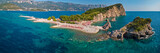 Aerial view of Sveti Nicola, Budva island, Montenegro. Hawaii beach, umbrellas and bathers and crystal clear waters. Jagged coasts with sheer cliffs overlooking the transparent sea. Wild nature