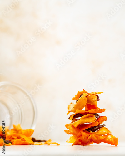 Stacked vegetable chips made from beetroot, carrot, parsnip on light colored background