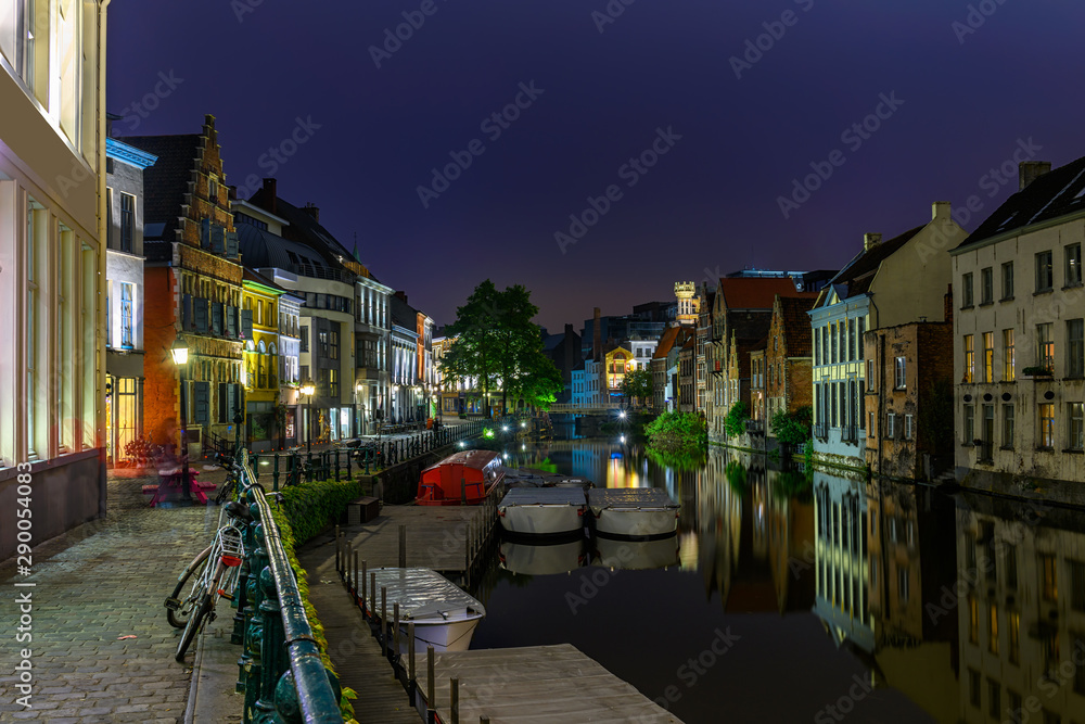 View of embankment of Leie river in the historic city center in Ghent (Gent), Belgium. Architecture and landmark of Ghent. Night cityscape of Ghent.