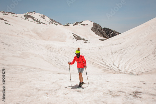 Girl walking on the dirty snow on the Tahtali mountain with hiking sticks