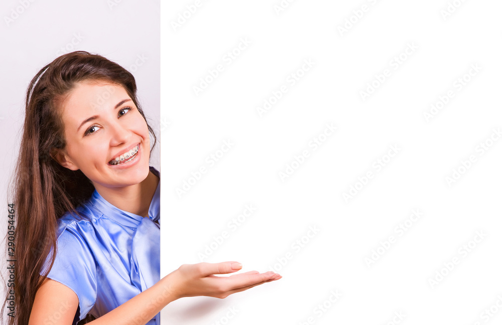 Attractive girl with braces presenting empty board Attractive girl with braces presenting empty board