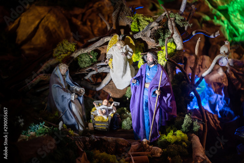 A classic biblical Christmas story made by figures: at the cradle with baby Jesus, his parents gathered - Virgin Mary, Joseph, as well as an angel, a turtledove, a lamb and other animals.