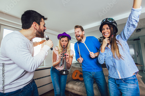 Group of friends playing karaoke at home. Concept about friendship  home entertainment and people