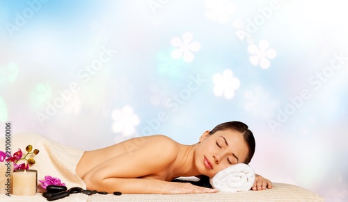 Beautiful young woman relaxing with stone massage at beauty spa