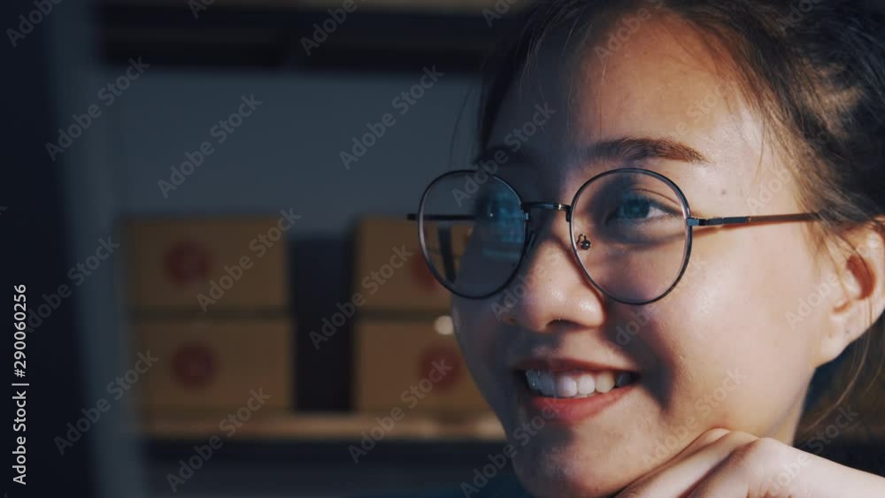 Asian girl are working sitting and smiling while using computer at night, Small business concept Asian girl are working sitting and smiling while using computer at night, Small business concept