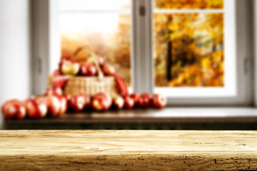 Wooden desk of free space and autumn window background 
