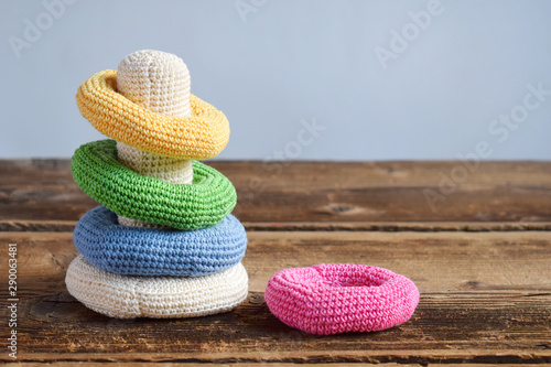 Crochet pyramid from colored rings. Toy for babies and toddlers to learn mechanical skills and colors. Handmade crafts. DIY concept.
