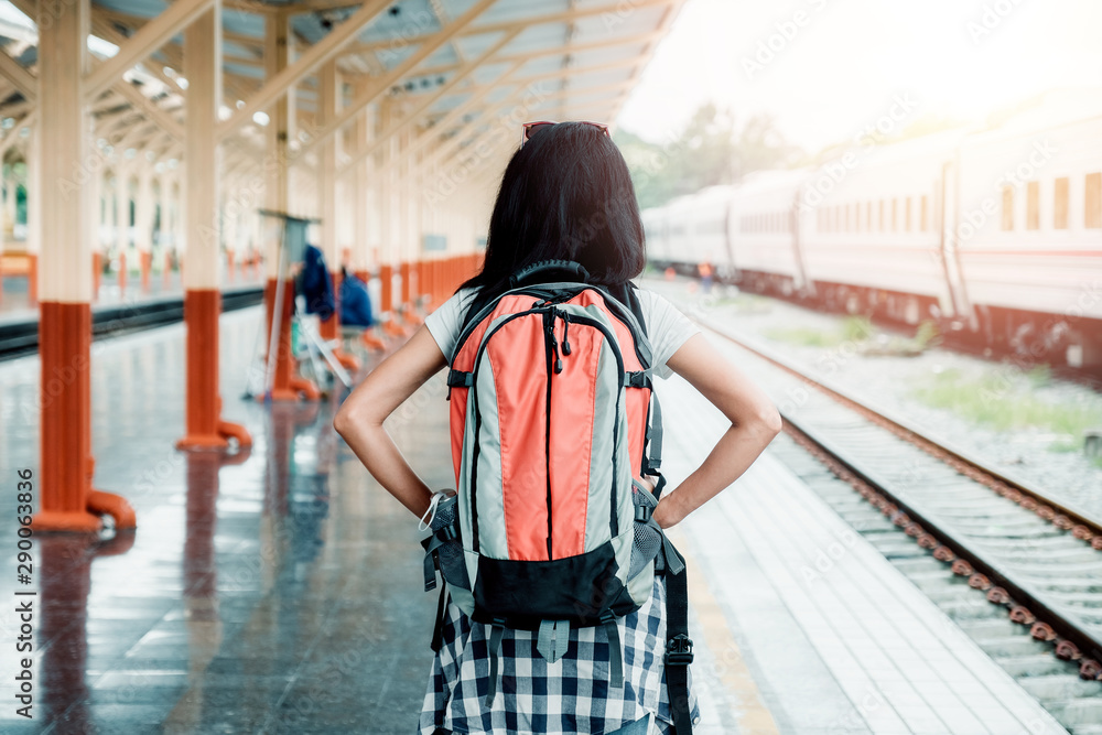 Obraz premium Traveling woman with backpack at the train station.