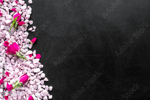 decorative pebble and roses frame for design on black background top view mock-up