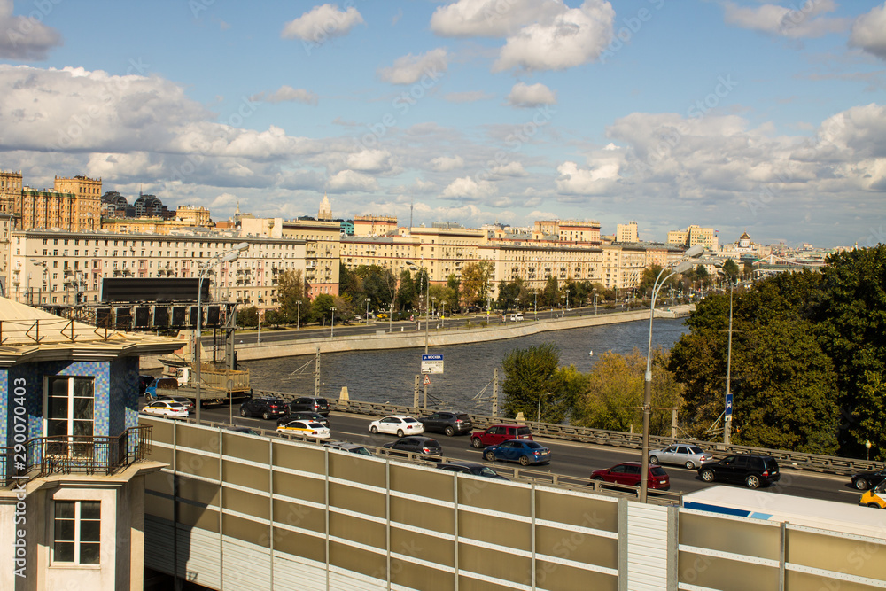 a view of the Moskva river and the embankment with historic buildings in the city centre a cloud on a summer day