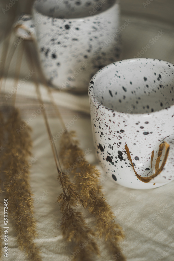 Obraz premium Two white cups on a linen tablecloth. Rustic background