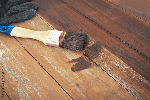paintbrush and gloves put on wood table.