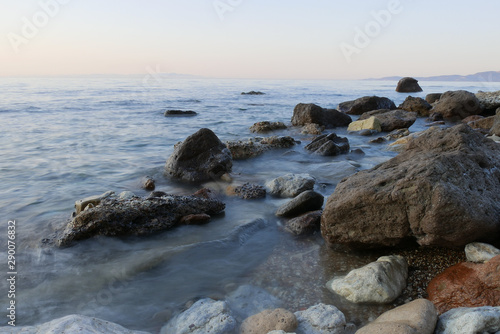 rocks in a sea with sunset. longer shutter © Eline