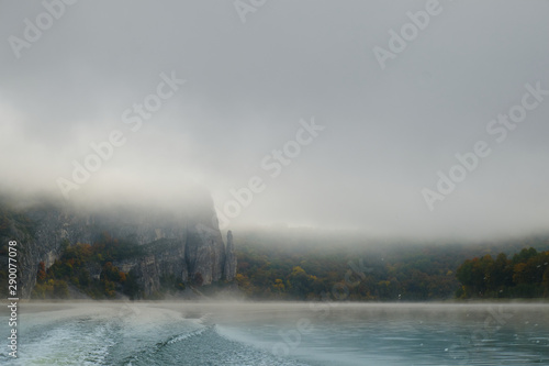 Walk on a mountain lake on a boat in the fog in the autumn. Boat fog fall. The trace of the boat on the water (Wake)