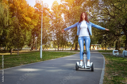Beautiful girl on a white hoverboard in the park, self-balancing scooter. Active lifestyle technology future copy space