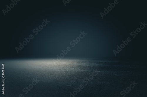 Abstract spacious place with dark wall, granular floor and spot light from above.