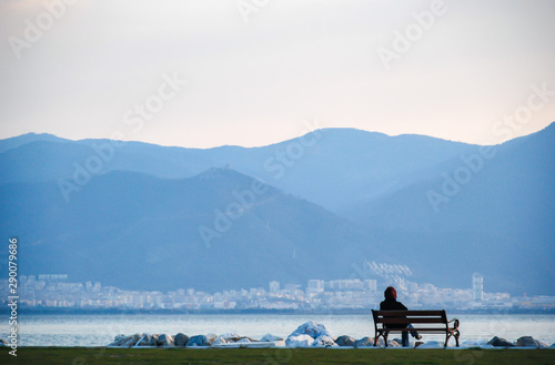 A Woman Sitting on the Bench near seaside and enjoying. © ersoy