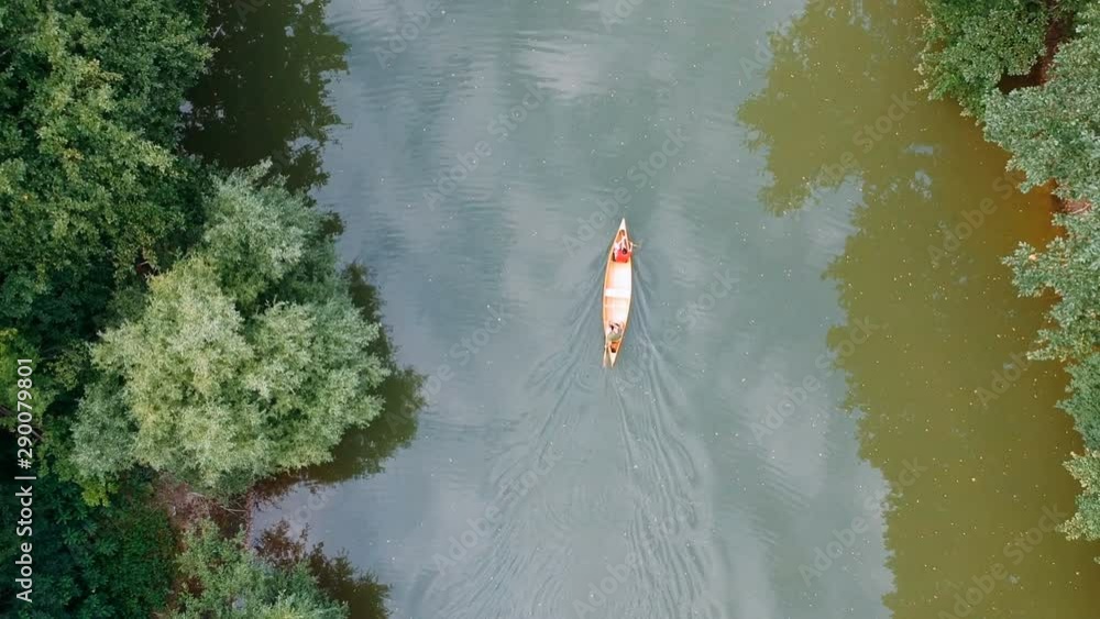 Tracking shot of men paddling canoe. Aerial view of the canoeists paddling boat Tracking shot of men paddling canoe. Aerial view of the canoeists paddling boat