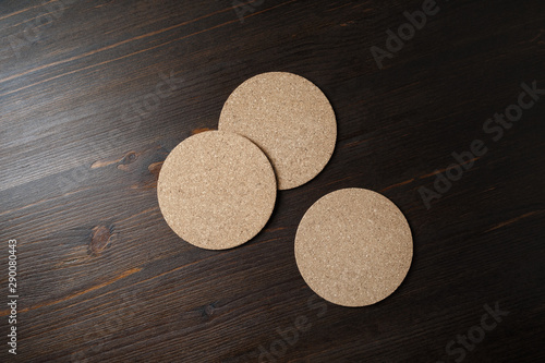 Three blank cork beer coasters on wooden background. Responsive design mockup. Flat lay.