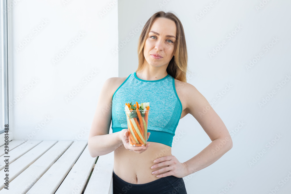 Diet concept - Healthy lifestyle woman holding vegetables indoors. Young female eating healthy food. Diet concept - Healthy lifestyle woman holding vegetables indoors. Young female eating healthy food.