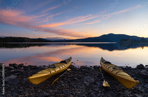 Two kayaks on the shore of a lake during a tranquil dusk. Jamtland, Sweden.