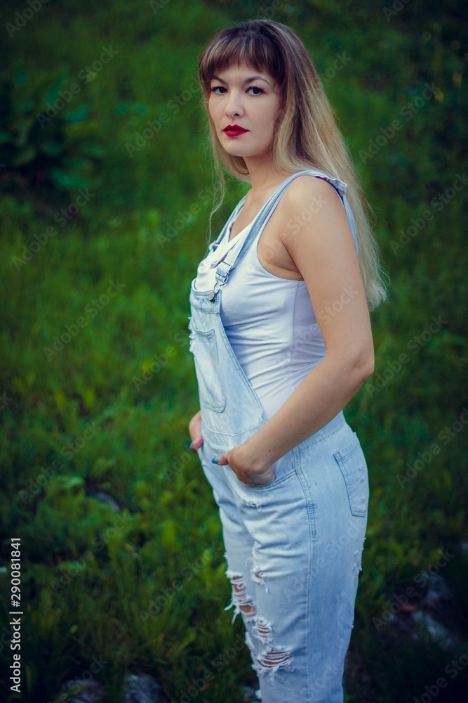 portrait of a young woman in overalls with long hair portrait of a young woman in overalls with long hair