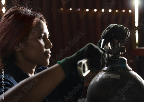Valokuva Mechanical engineer woman using wrench hand tool to repair valve on gas cylinder