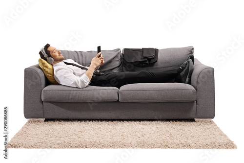 Businessman lying on a sofa and listening to music © Ljupco Smokovski
