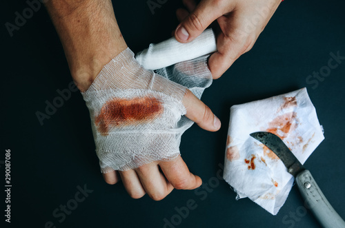 Valokuva Man is putting the bandage on the wound