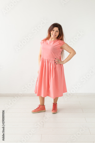 Wallpaper Mural Beautiful young cheerful woman in a long peach dress posing on a white wall. Concept of stylish young woman. Torontodigital.ca