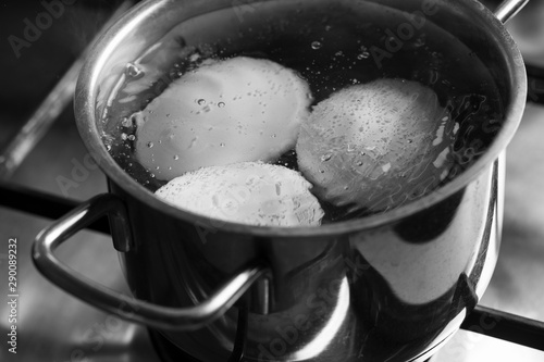 Cooking boiled eggs in pan on stove  