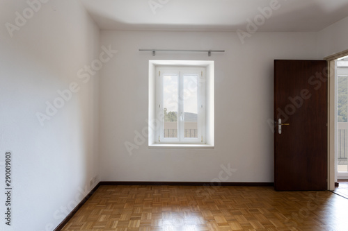 Empty room with white walls and window overlooking nature