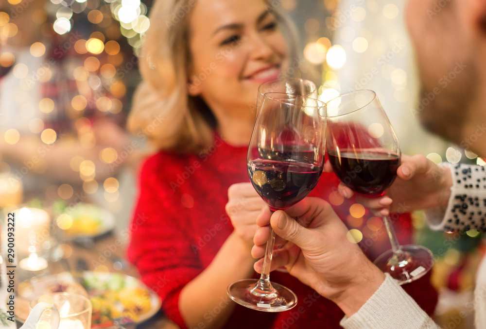 holidays and celebration concept - close up of happy friends having christmas dinner at home, drinking red wine and clinking glasses holidays and celebration concept - close up of happy friends having christmas dinner at home, drinking red wine and clinking glasses