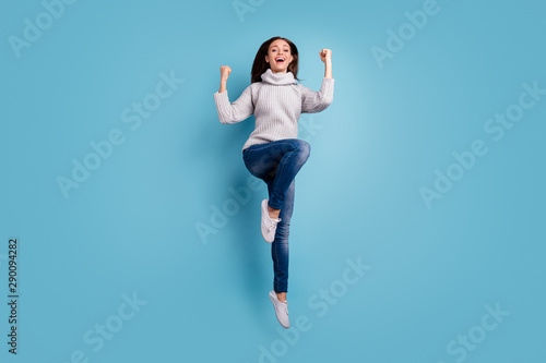Full body photo of lovely sweet cute youth true champion raise fists scream yeah celebrate victory triumph jump wear trend clothes sneakers isolated over blue color background