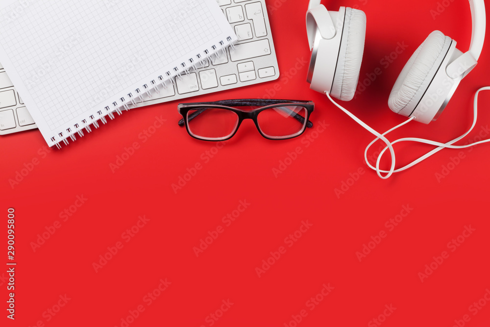 Office red workplace with headphones, supplies and computer Office red workplace with headphones, supplies and computer