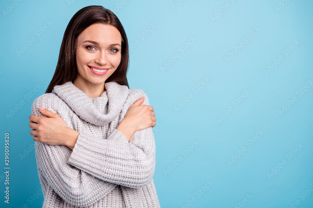 Turned photo of charming content lady hug herself cuddling feel glad wear white knitted sweater pullover isolated over blue color background Turned photo of charming content lady hug herself cuddling feel glad wear white knitted sweater pullover isolated over blue color background