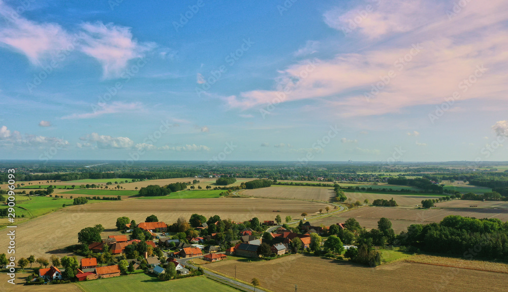 Aerial view of a blue sky with white clouds over a small village