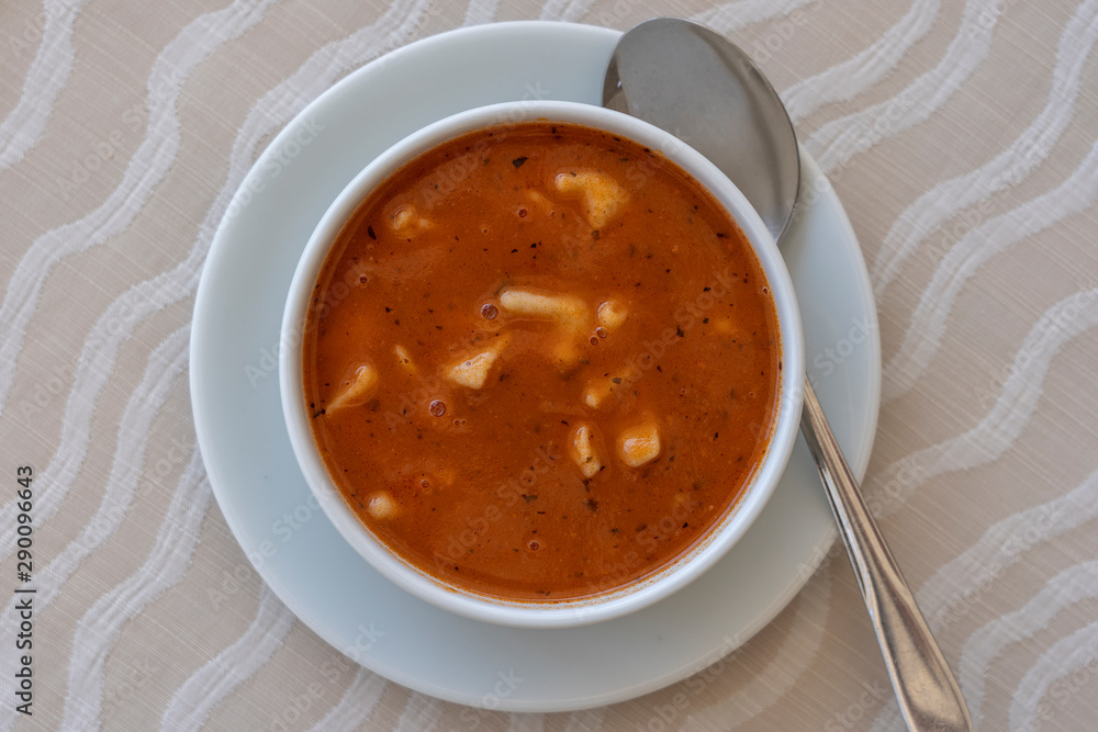 Red tomato soup with dumplings in a white bowl, close up Red tomato soup with dumplings in a white bowl, close up