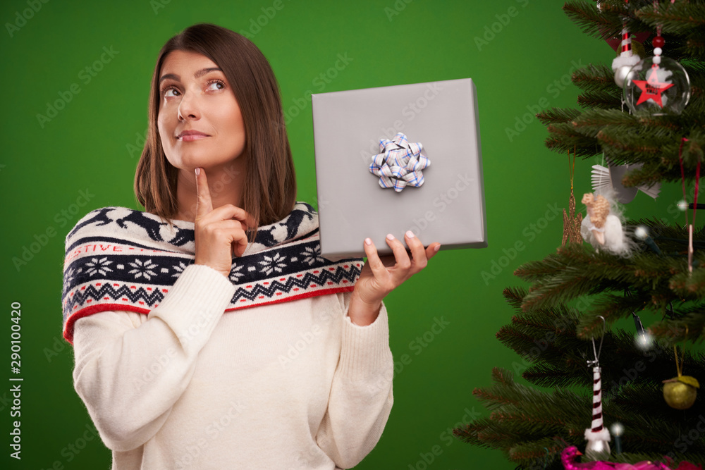 Adult happy woman with Christmas gift over green background Adult happy woman with Christmas gift over green background