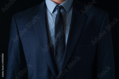 Young man in a blue suit on a dark background