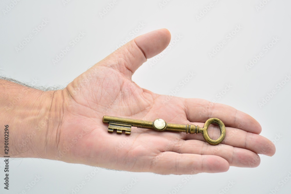 mano sujetando una llave antigua de diferentes formas
