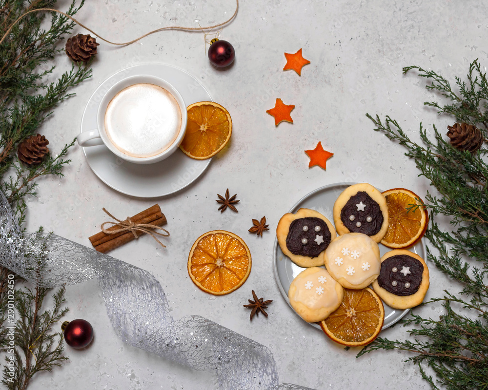 Christmas still life with decorated cookies, a cup of coffee. Light background with fir branches, anise stars, slices of dry orange, cinnamon, Christmas balls. Christmas still life with decorated cookies, a cup of coffee. Light background with fir branches, anise stars, slices of dry orange, cinnamon, Christmas balls.