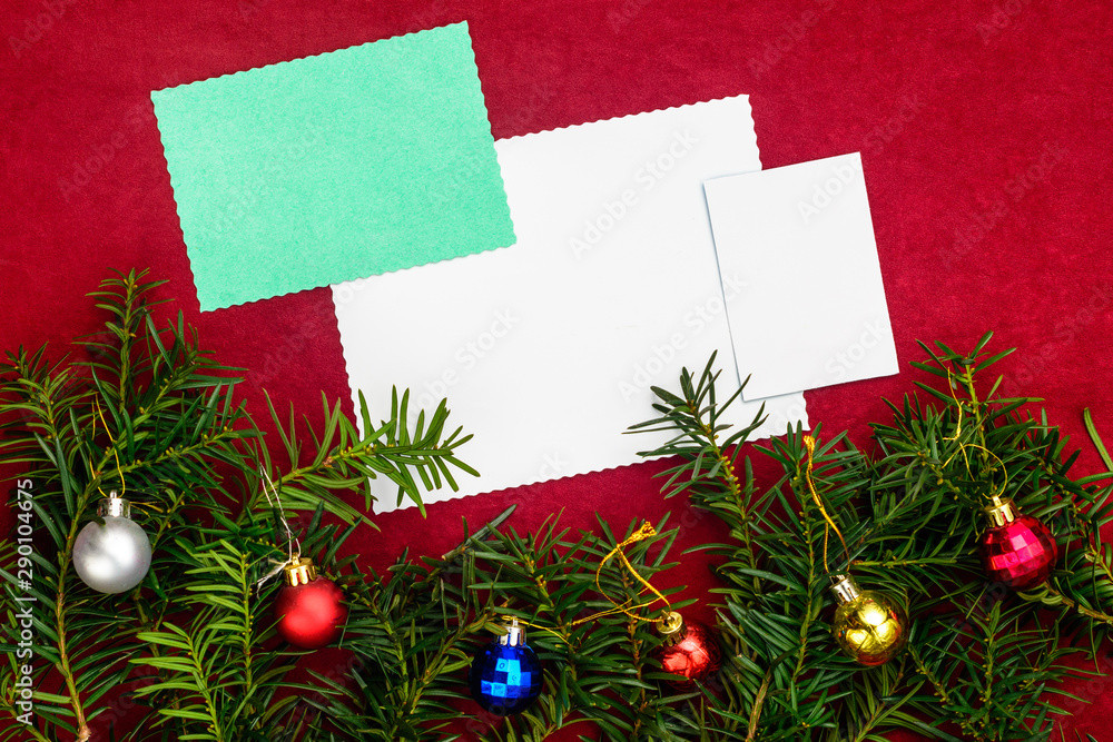 Piece of paper for Christmas wishes on a red background with branches of Christmas tree and Christmas balls. Piece of paper for Christmas wishes on a red background with branches of Christmas tree and Christmas balls.