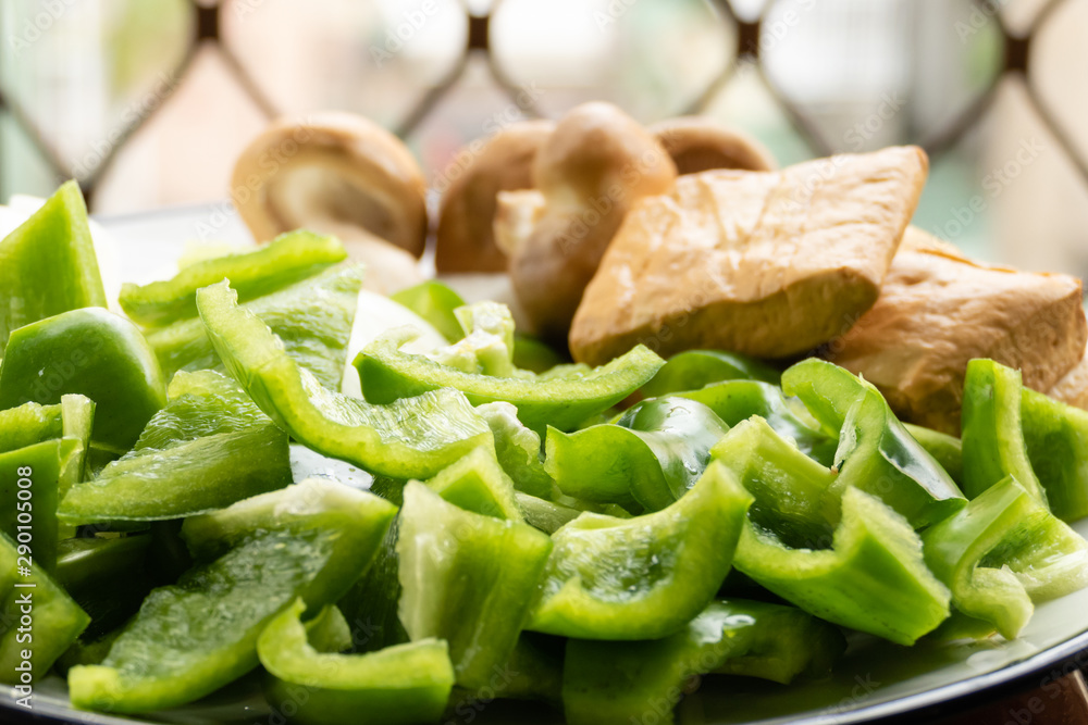 Green peppers, tofu, onion, and mushrooms in plate Green peppers, tofu, onion, and mushrooms in plate
